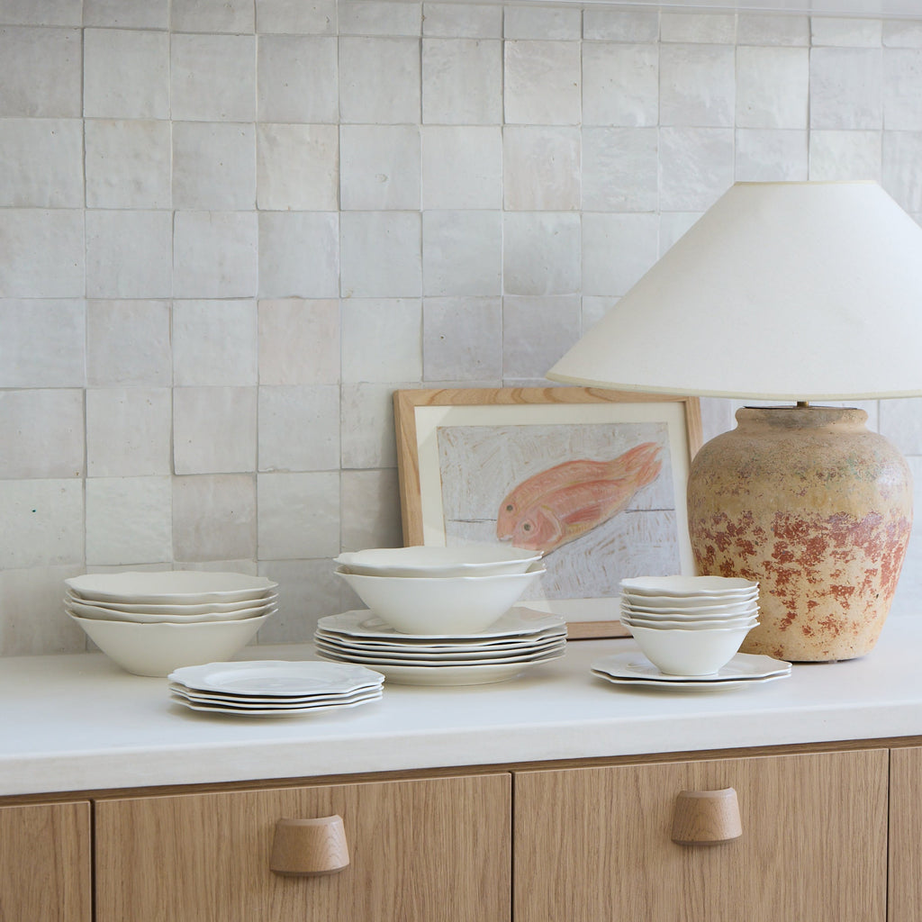 Kitchen with white cabinets, tiled backsplash, and decorative items on a countertop.