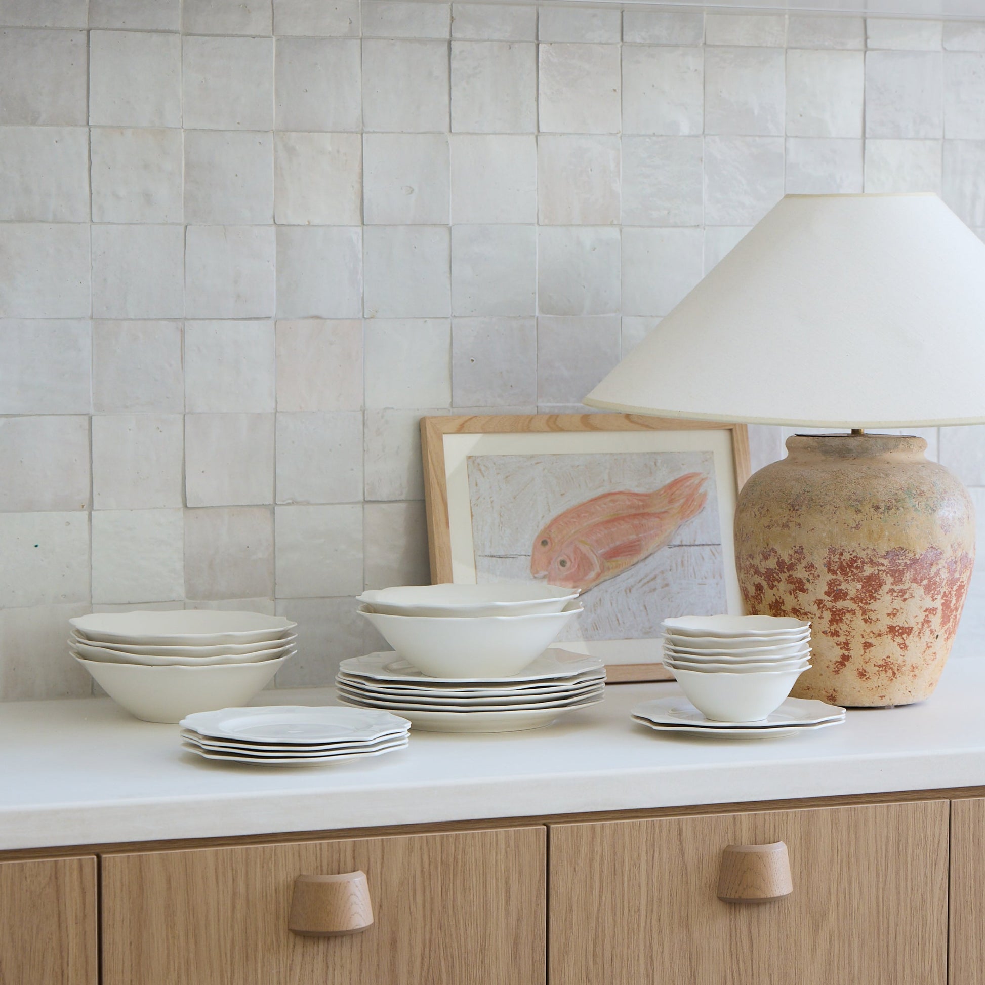 Kitchen with white cabinets, tiled backsplash, and decorative items on a countertop.